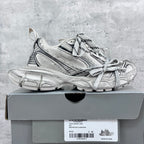 Balenciaga unisex sneakers in silver with black accents, on a shoe box