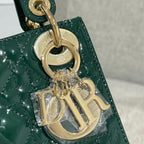 Gold-tone charm and ring hardware on a green Dior handbag with quilted texture