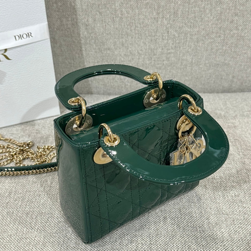 Green Dior handbag on chain with top handles, gold-tone hardware, and charm