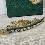 Green Dior handbag bottom edge with gold-tone chain and quilted front panel