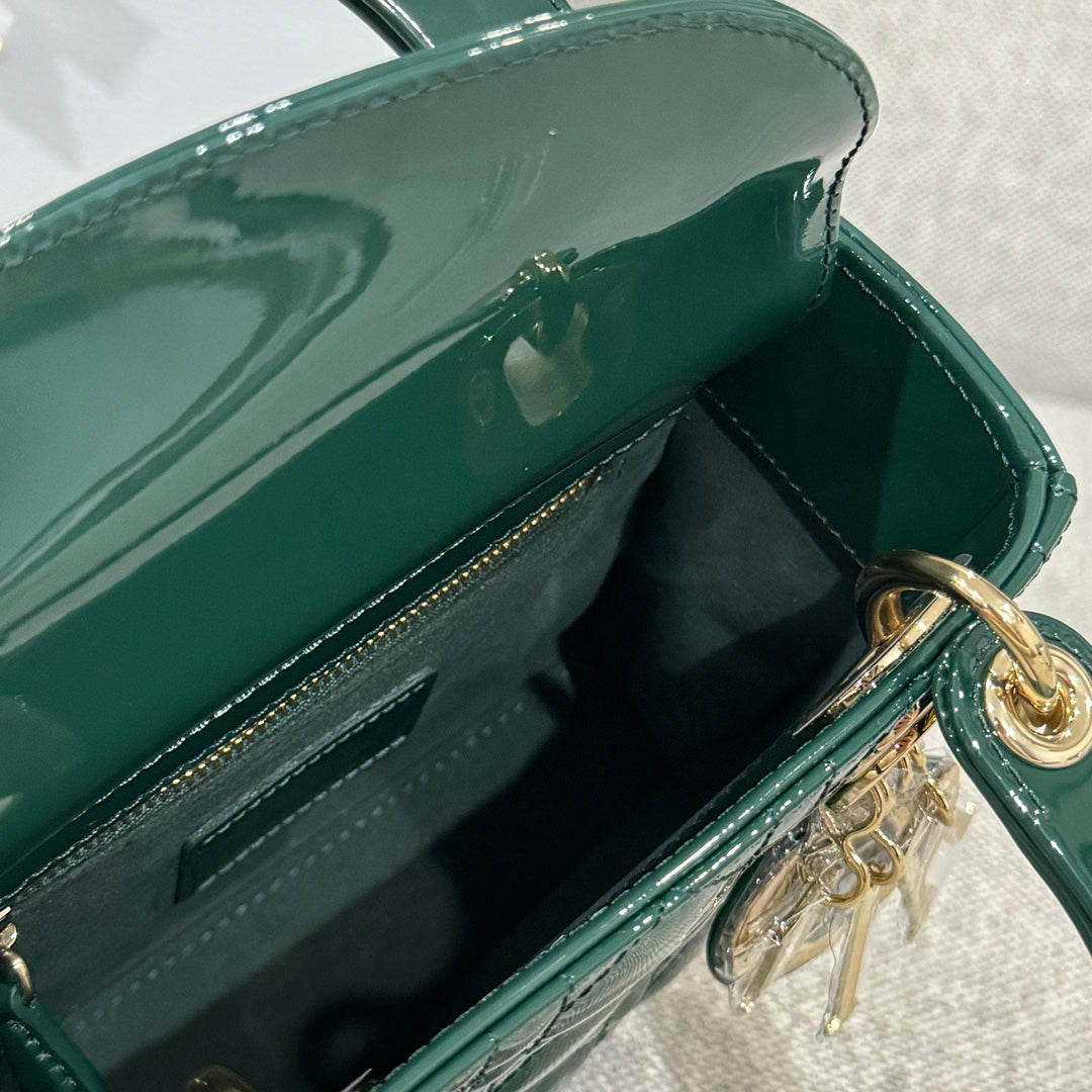 Interior view of green Dior handbag with snap opening, stitching, and gold-tone ring