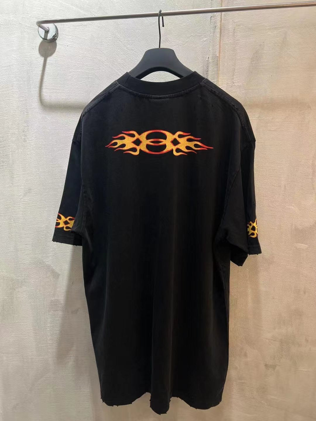 Black Balenciaga T-shirt front with orange flame logo and small sleeve flame print