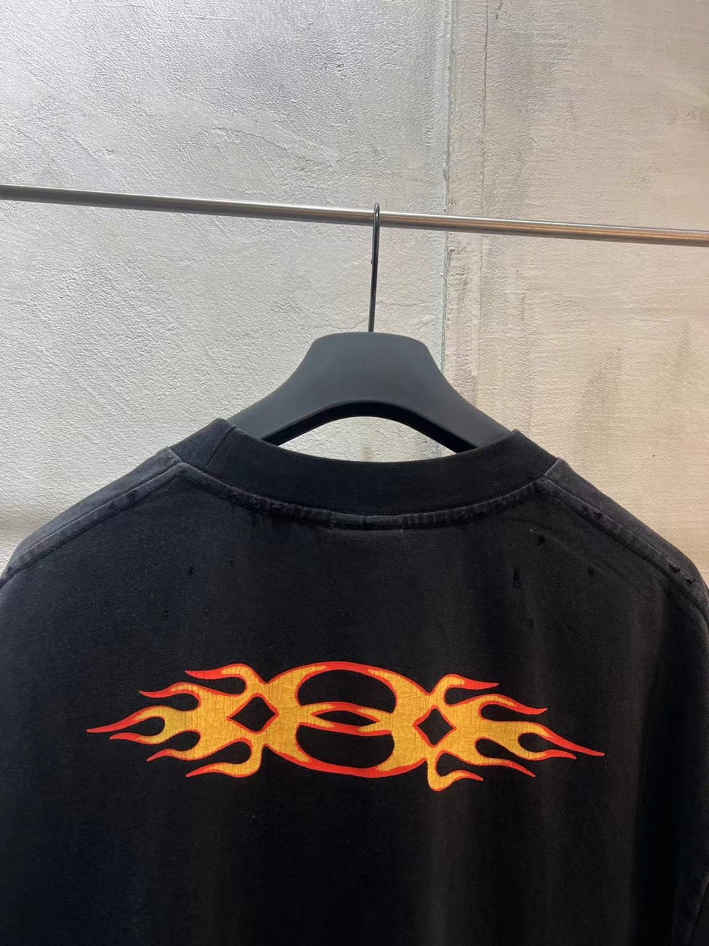 Black Balenciaga T-shirt back with large orange flame graphic across shoulders