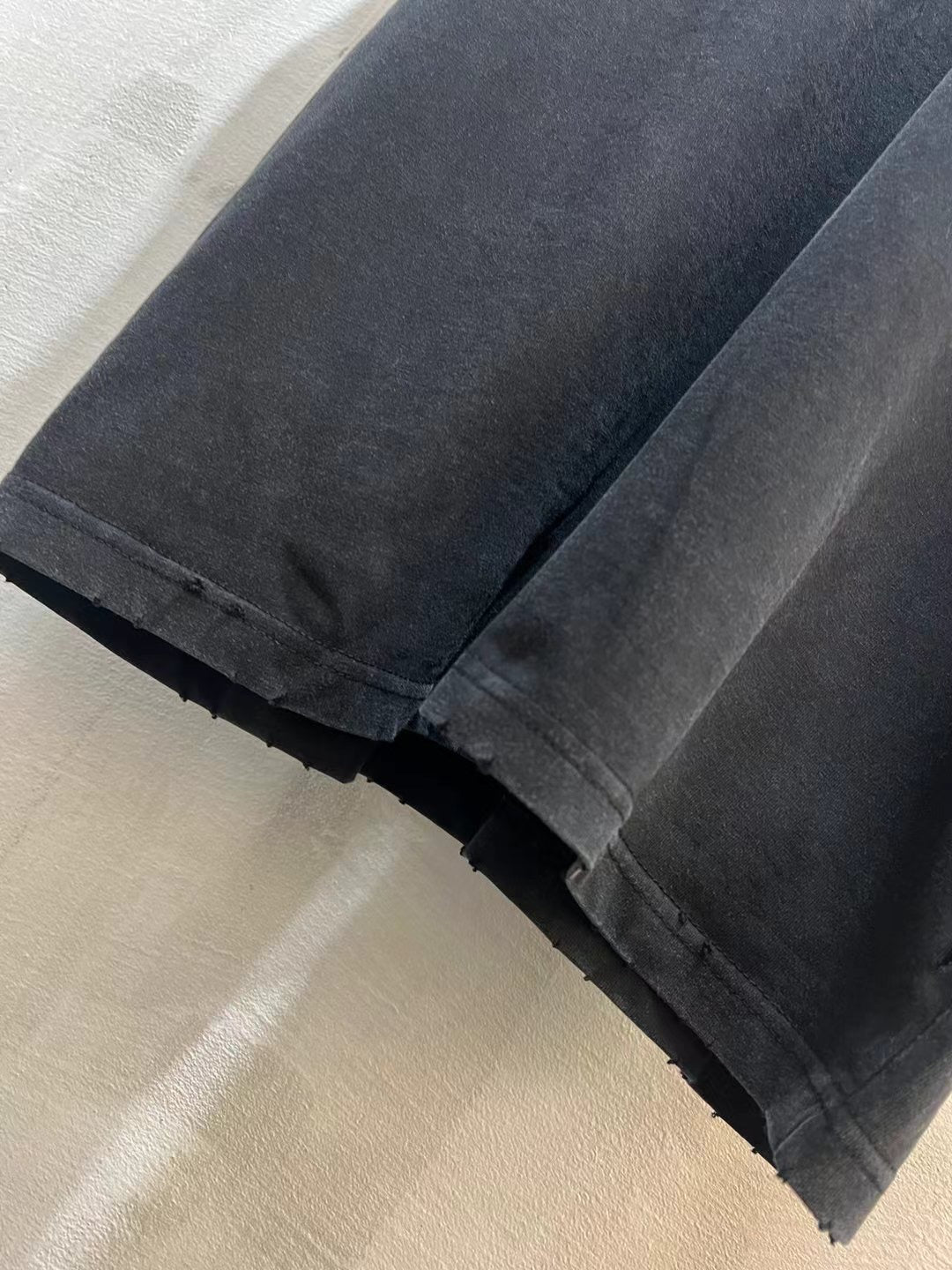 Black Balenciaga T-shirt fabric close-up at cuff and folded hem