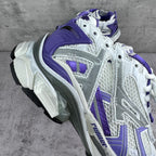 Unisex runner sneakers angled view, white upper with bold purple overlays and laces