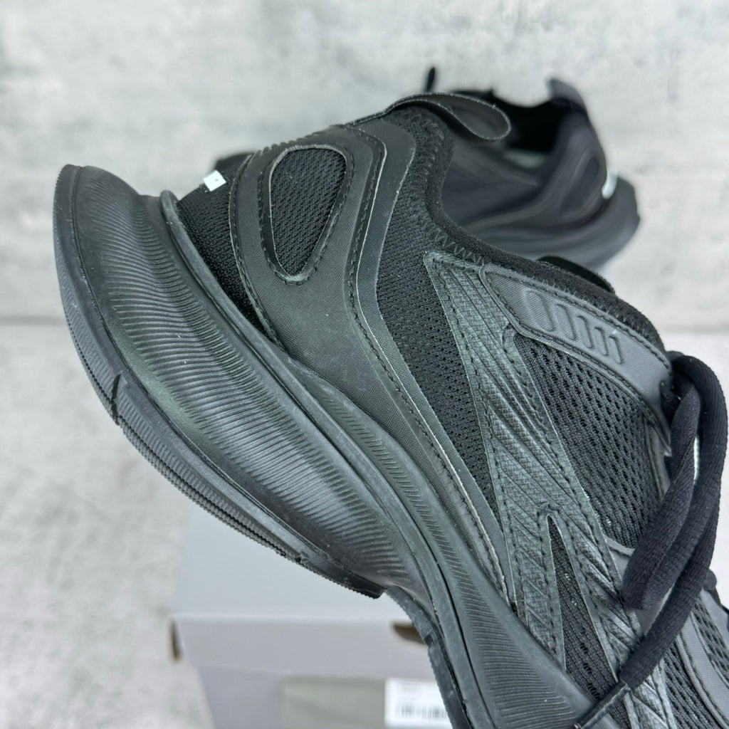 Dark gray/black unisex sneaker with padded heel, perforated panels, and thick tread sole