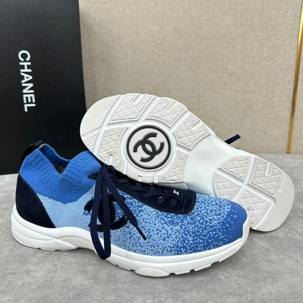 Unisex blue knit sneakers with dark navy laces and patterned white outsole tread
