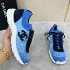 Unisex blue knit sneakers with black side panels, dark navy laces, and white sole