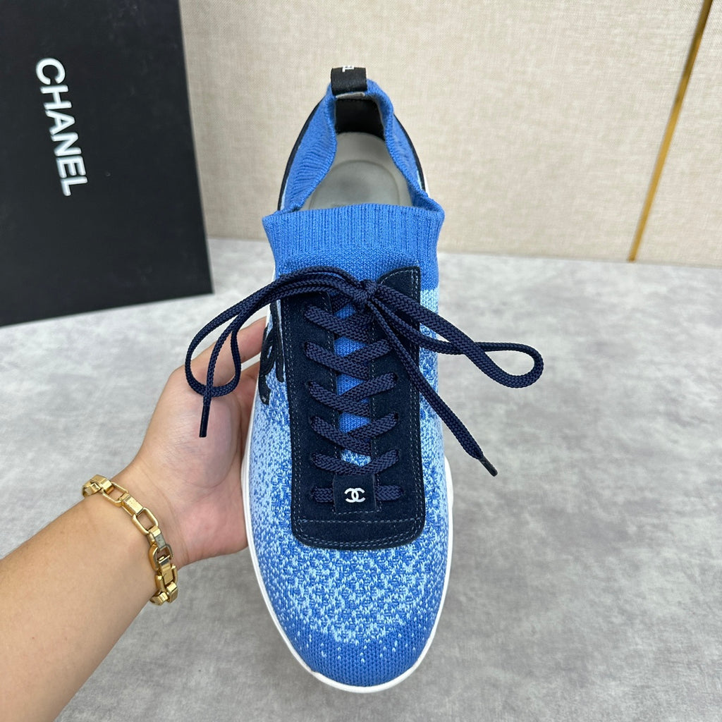 Unisex blue knit sneakers showing front, dark navy laces, black logo patch, white sole