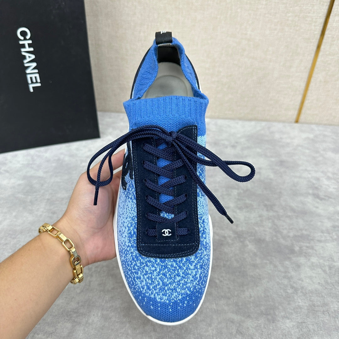 Unisex blue knit sneakers showing front, dark navy laces, black logo patch, white sole