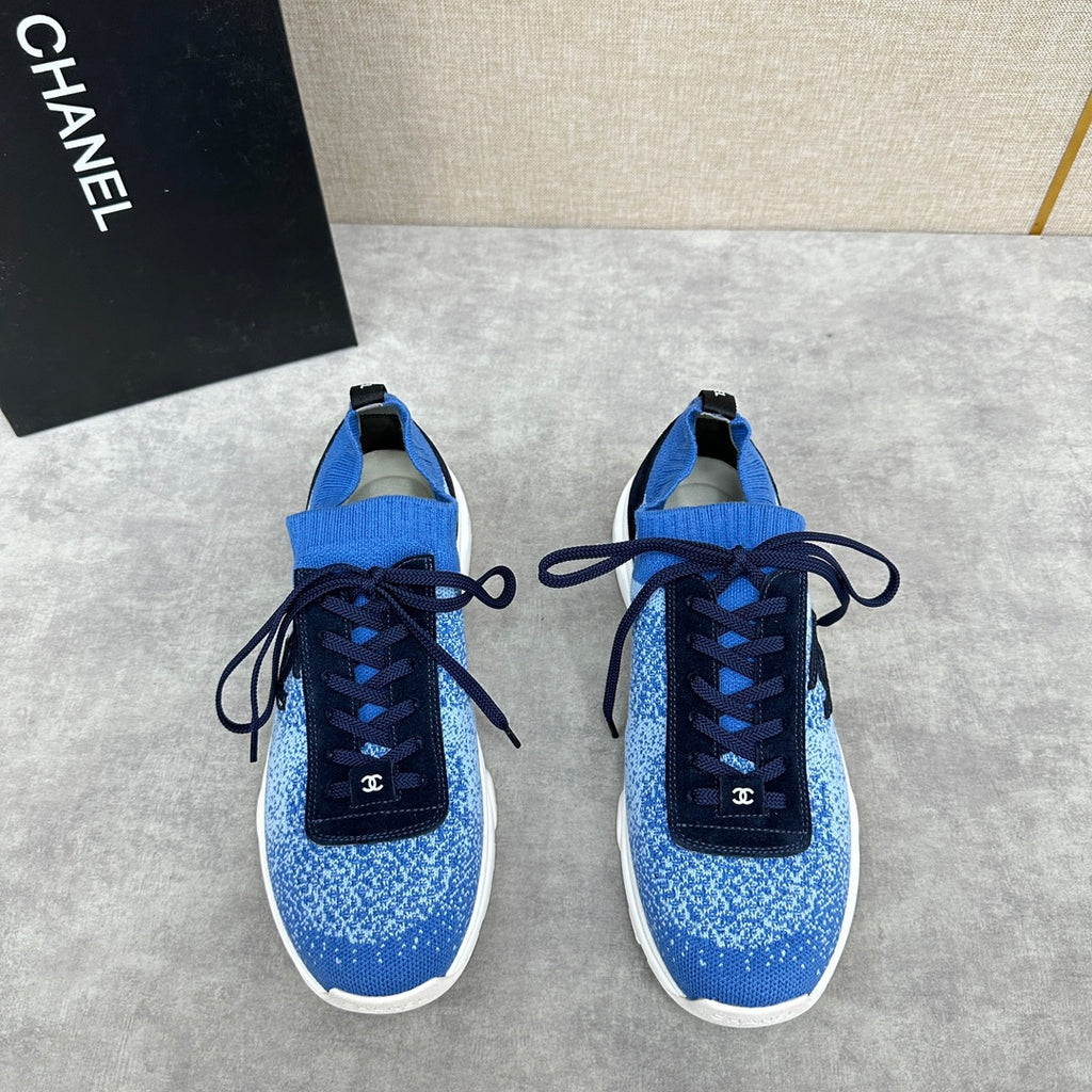 Unisex blue knit sneakers with dark navy laces, white sole, and black logo patch