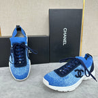 Unisex blue knit sneakers with dark navy lace-up, black logo patch, and white sole