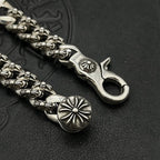 Silver-tone chain bracelet end with open clasp, flower medallion, and raised links