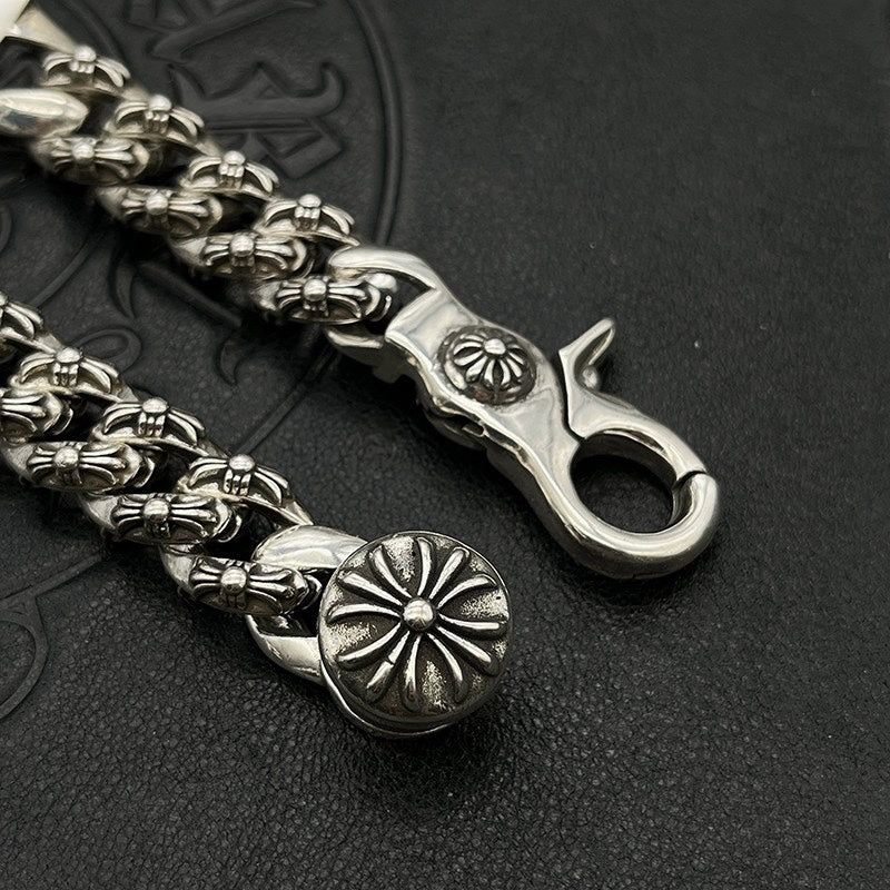 Silver-tone chain bracelet end with open clasp, flower medallion, and raised links