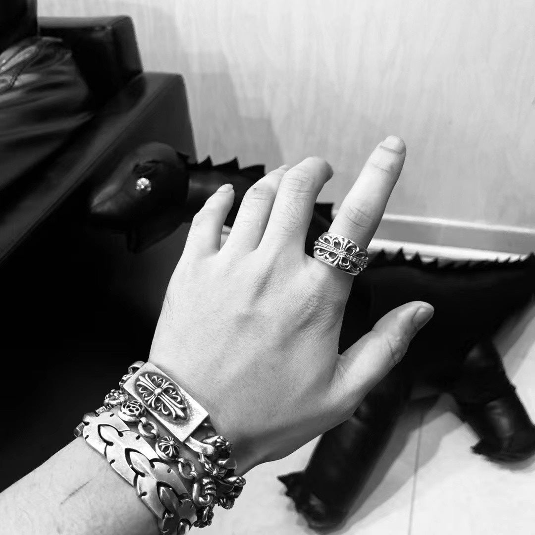 Silver-tone chain bracelet on hand with ornate link details and coordinating rings