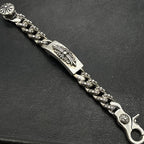 Silver-tone chain bracelet with engraved rectangular panel, bead-like links, and flower clasp