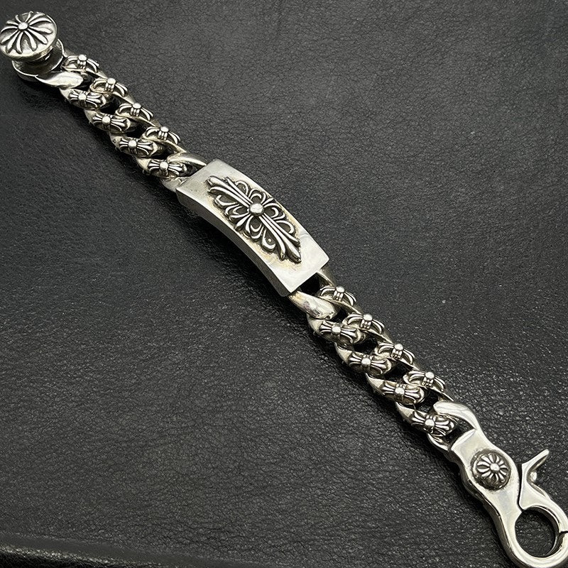 Silver-tone chain bracelet with engraved rectangular panel, bead-like links, and flower clasp