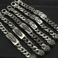 Silver-tone chain bracelet with decorative links and engraved rectangular plates