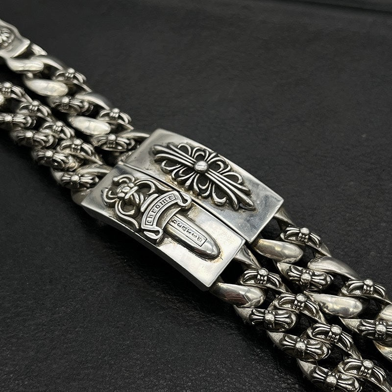 Silver-tone chain bracelet detail with ornate rectangular plate and etched centerpiece