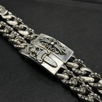 Silver-tone chain bracelet detail with ornate rectangular plate and etched centerpiece