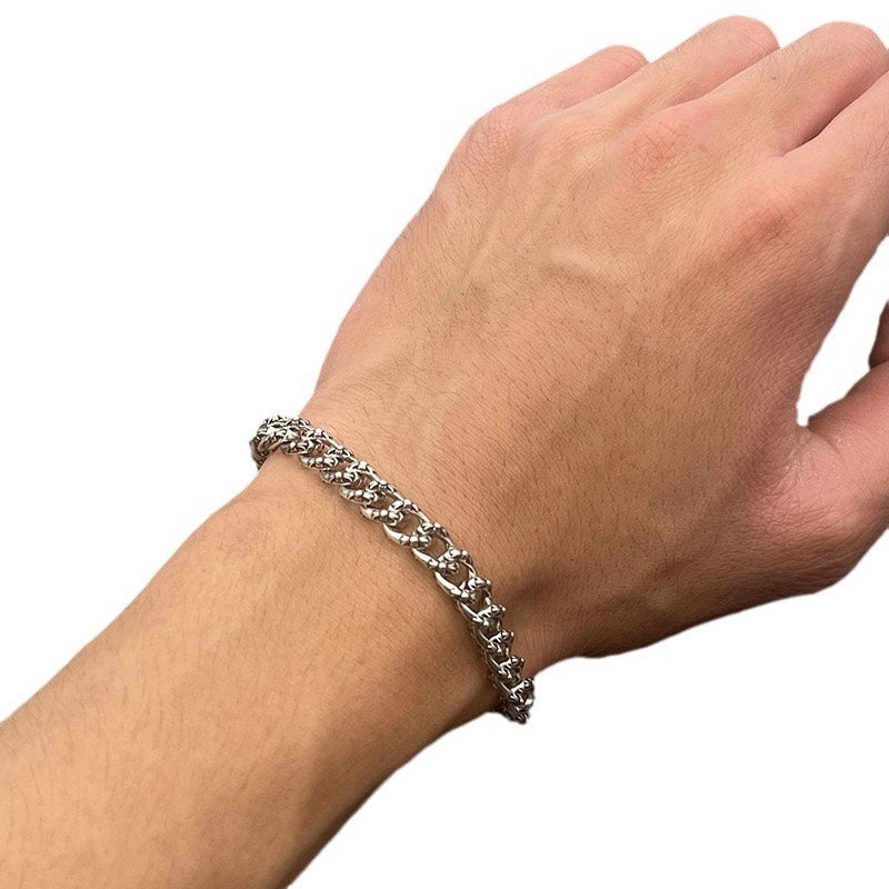 Chrome bracelet on wrist with silver-toned curb link chain