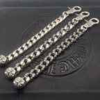 Silver-toned chain bracelet with twisted links and small flower charms, curved tips