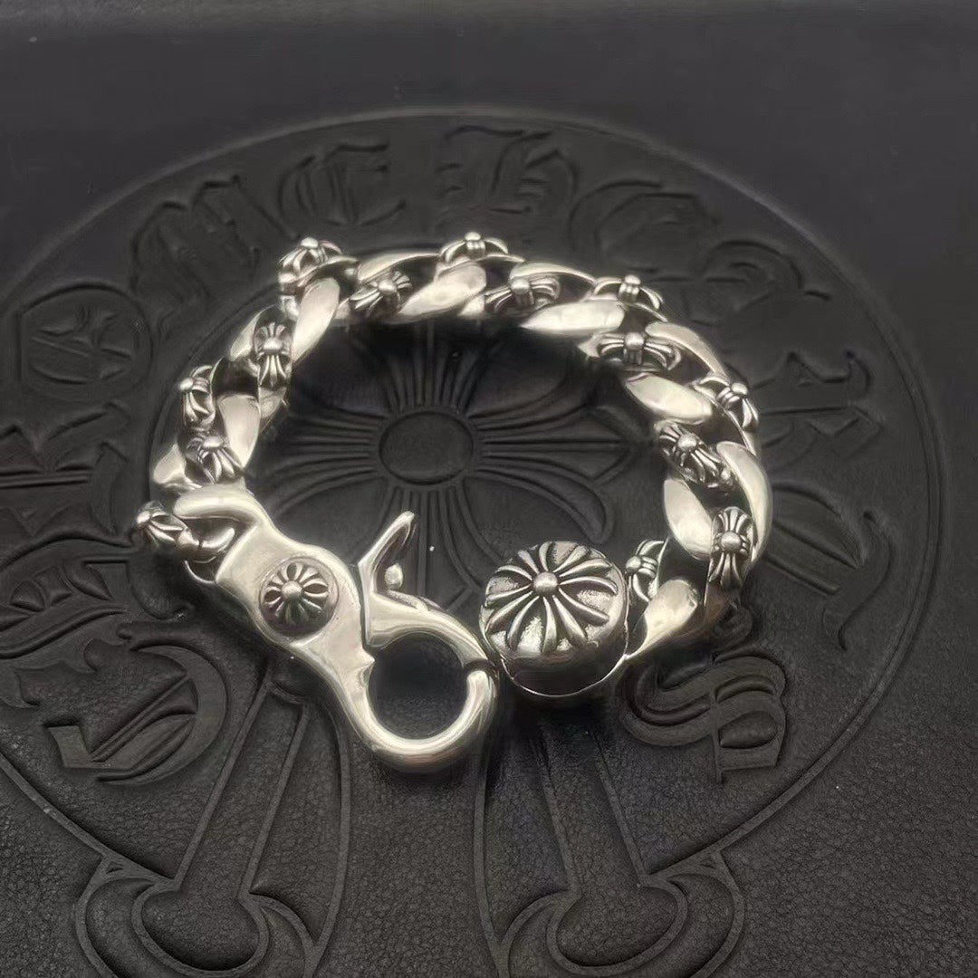Silver-toned circular bracelet with twisted links and flower medallion charms at the ends