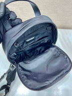 Black Prada mini backpack open with nylon lining and dual zipper pockets