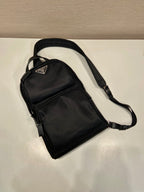 Black Prada mini backpack with adjustable shoulder strap, front zip pocket and logo
