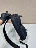 Black Prada mini backpack side view with strap and zipper pull, silver rings