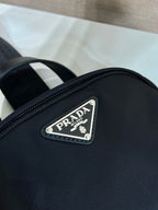 Prada logo patch on black mini backpack front, silver riveted label