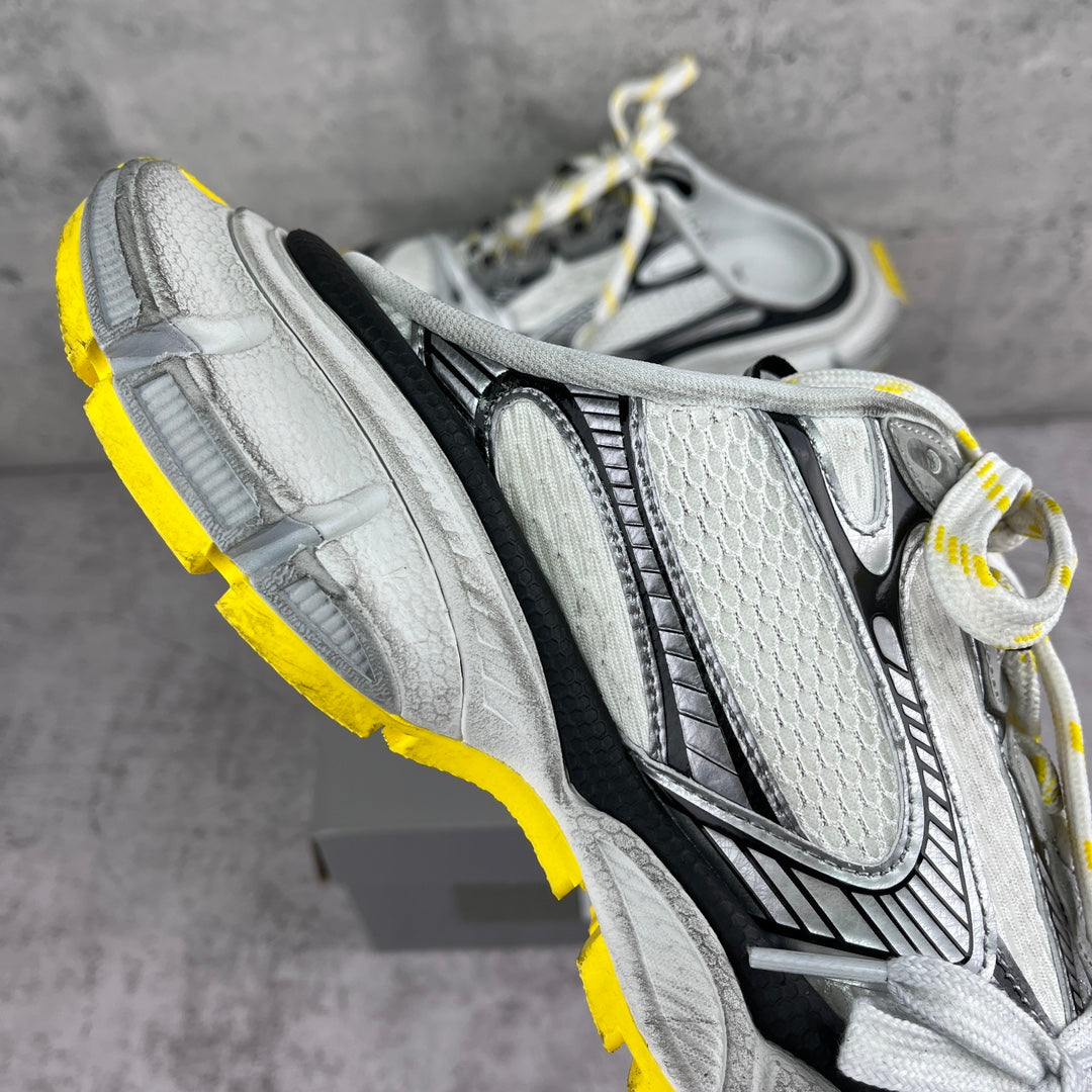 Gray chunky sneakers with textured panels, black accents, and white laces; yellow sole.