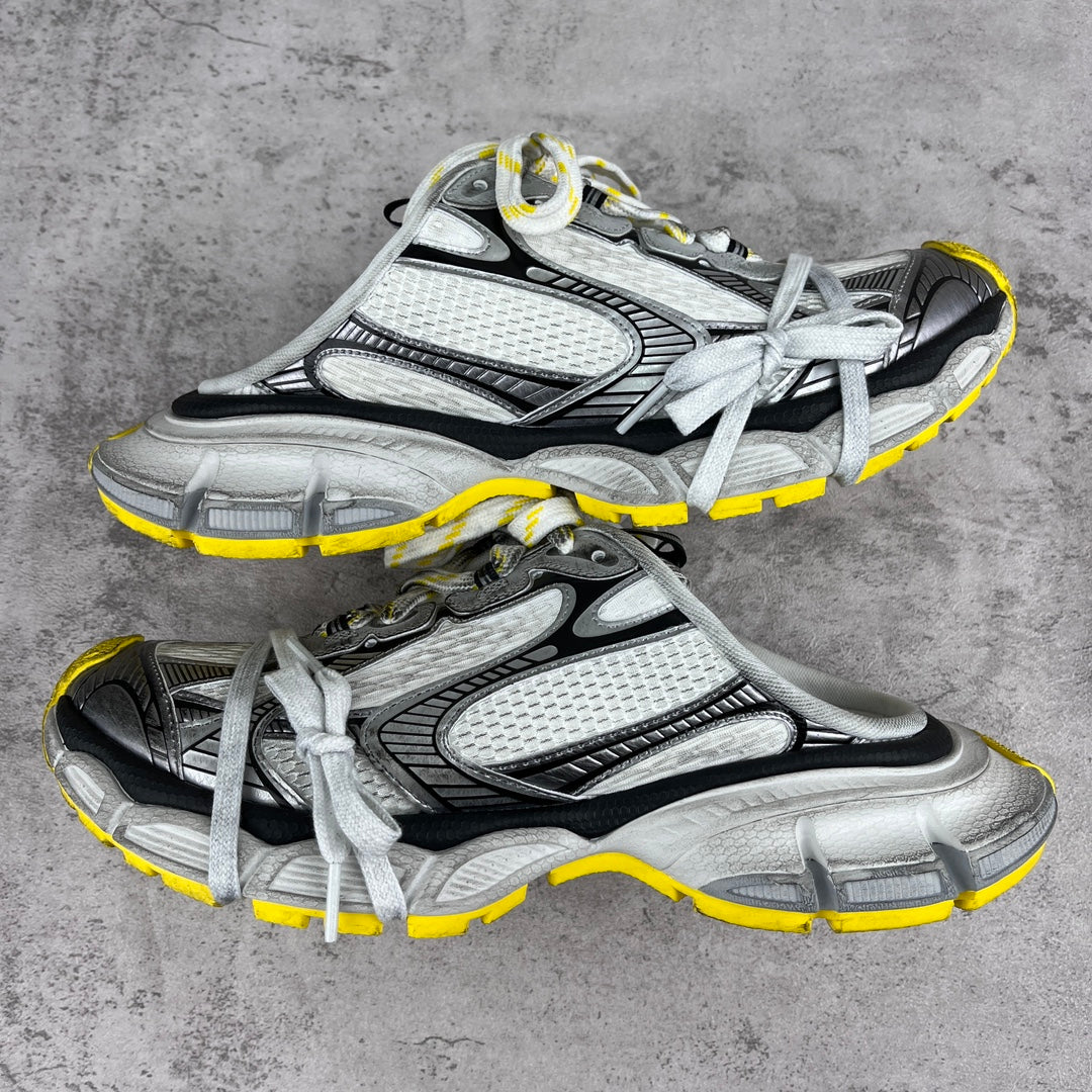Gray and black chunky sneakers with white laces and yellow trim, unisex style.