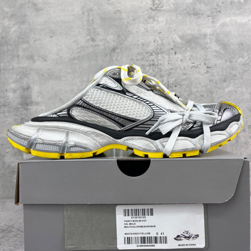 Gray and black chunky sneakers with mesh panels, white laces, yellow outsole trim.