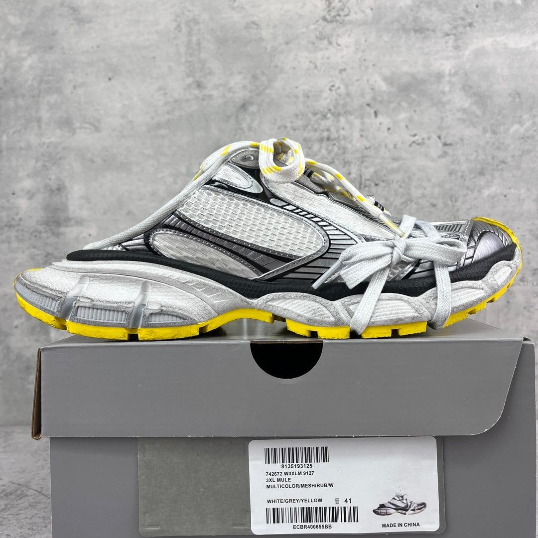 Gray and black chunky sneakers with mesh panels, white laces, yellow outsole trim.
