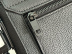 Black leather bag zipper pull and metal track hardware detail