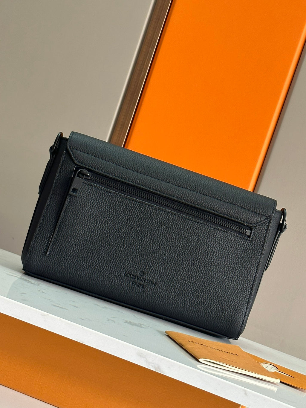 Men's black zippered wallet bag with adjustable shoulder strap and emblem