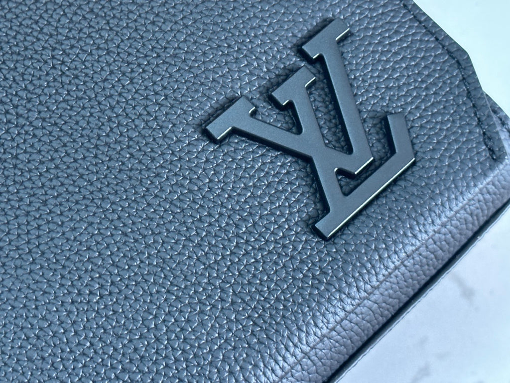 Black textured leather bag with raised LV-style emblem detail