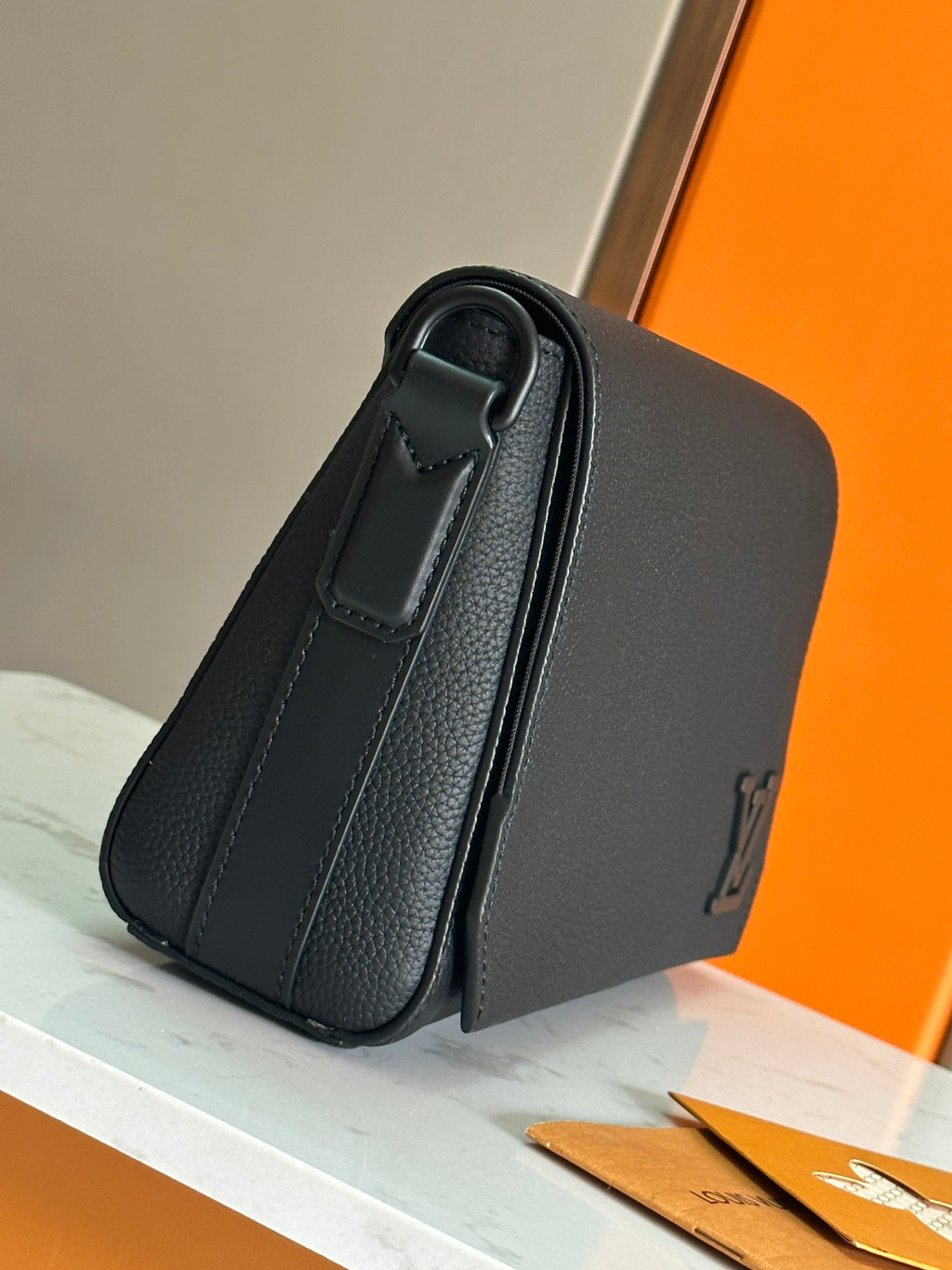 Men's black crossbody bag with top handle and textured leather exterior