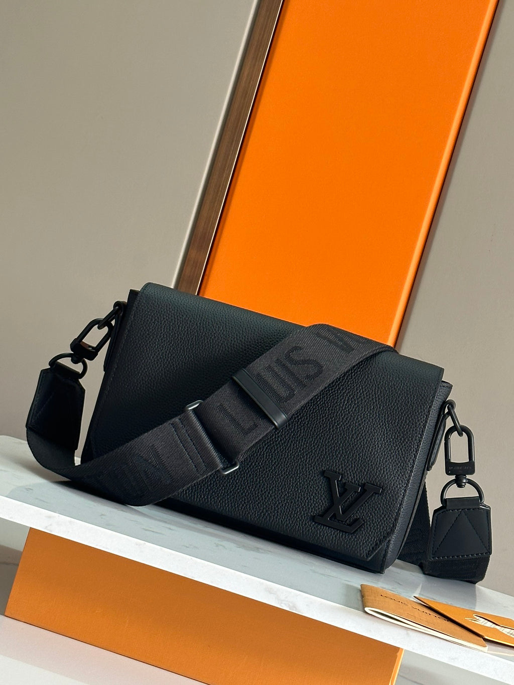 Louis Vuitton men's black crossbody bag with flap and front emblem