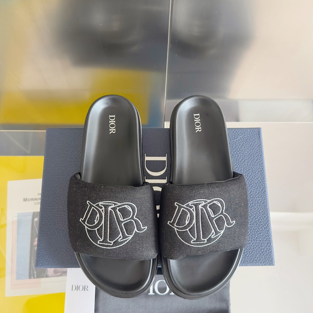 Black Dior slide sandals with fabric logo straps and thick molded footbeds