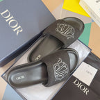 Black Dior slide sandals with wide strap and white Dior monogram, open-toe style
