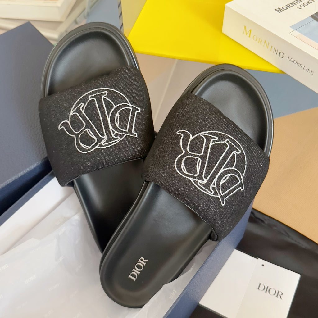 Black slide sandals with fabric straps and white Dior monogram, close pair view