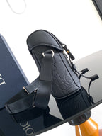 Dior bag with textured dark leather, adjustable strap and front buckle detail.