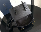 Dior bag with front flap and contrast panels, showing shoulder strap and buckles.