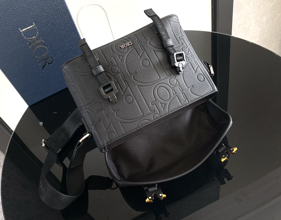 Dior bag with front flap and contrast panels, showing shoulder strap and buckles.