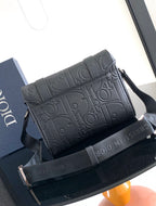 Dior bag with embossed monogram pattern and top flap with dark strap.