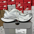 White unisex sneakers with mesh panels and black rubber sole
