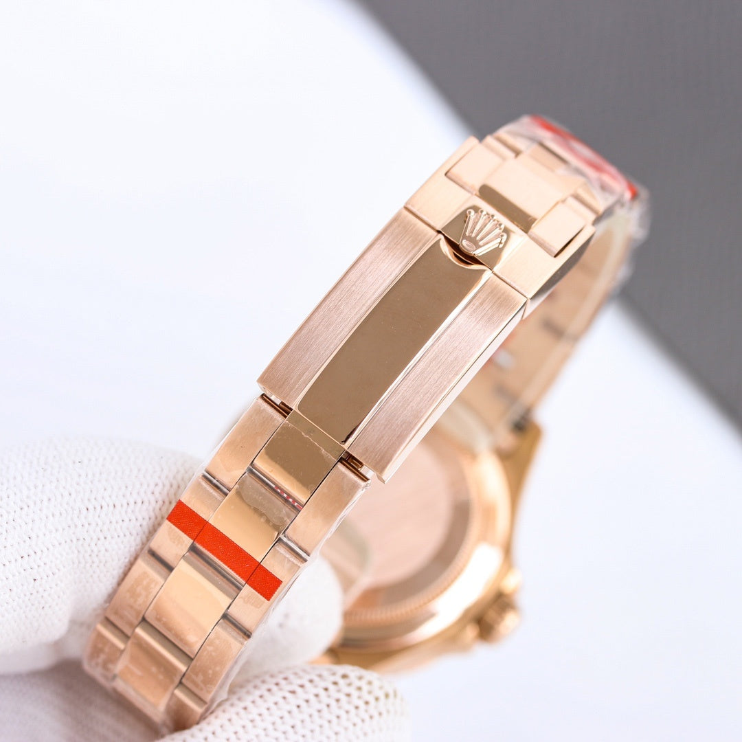 Rolex watch bracelet clasp in rose-gold tone with red accent bars and hinged links.