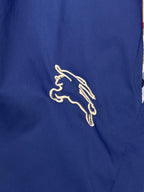 Embroidered Burberry horse logo on blue fabric shorts
